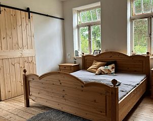 Rustieke slaapkamer in Vakantiehuisje in Dannenberg (Elbe), Nedersaksen, met houten meubels en uitzicht op de natuur.