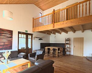 Gezellige woonkamer van Vakantiehuisje in Vrees, Nedersaksen, Duitsland met houten interieur en ruime zithoek.