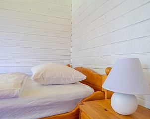 Gezellige slaapkamer in Vakantiehuisje in Vrees, Nedersaksen. Comfortabel verblijf in Duitsland met houten interieur.