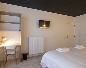 Comfortabele slaapkamer met bureau en tv in Meet Enjoy vakantiehuis, Nieuwpoort.