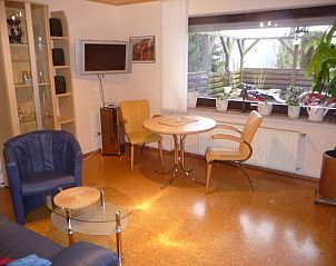 Cozy living room in Weserbergland-fewo Gabriel apartment, Bodenwerder, with comfortable chairs and views of the garden.