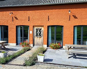 Red brick facade of Pladutse Gite vacation home in Kluisbergen, East Flanders, with terrace.