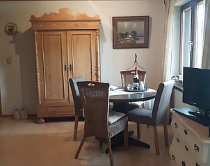 Gezellige eetruimte in Huisje in Waldeck, vakantiehuis in Hessen, Duitsland, met houten kast en ronde tafel.
