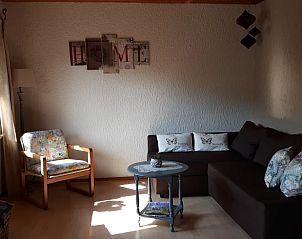 Gezellige woonkamer in Huisje in Waldeck, vakantiehuis in Hessen, Duitsland, met comfortabele zithoek en sfeervolle decoratie.