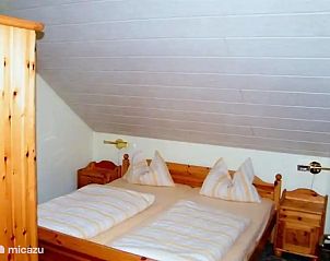Gezellige slaapkamer in Seepark Dorp 4 nr.19 Kirchheim, vakantiehuis in Hessen, Duitsland, met houten meubels en comfortabel bed.