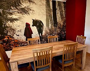 Gezellige eetruimte in Vakantiehuisje in Alheim, Hessen, Duitsland met sfeervol bosbehang en houten eettafel.