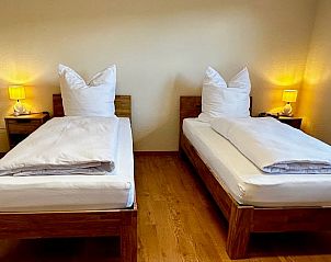 Gezellige slaapkamer in Vakantiehuisje in Alheim, Hessen met twee eenpersoonsbedden en warme verlichting.