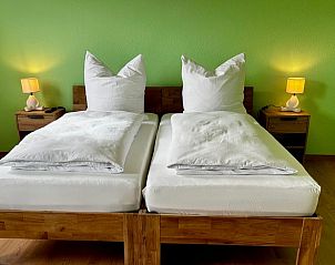 Slaapkamer in Vakantiehuisje in Alheim, Hessen, Duitsland met comfortabele bedden en sfeervolle verlichting.