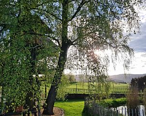 Enjoy the serene nature surrounding the Holiday Home in Mrlenbach, Eifel, with stunning views of green fields and trees.