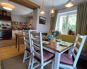 Cozy dining area in Holiday Home in Mrlenbach, Eifel overlooking the green surroundings.