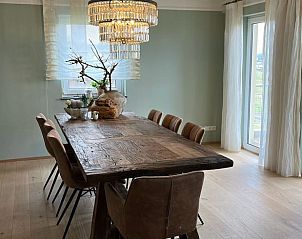 Stylish dining room in Holiday Home in rzig, located in the picturesque Eifel/Moselle region of Germany, with rustic wooden table.