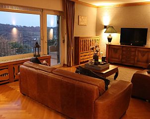 Gezellige woonkamer van Ferienhaus Blick auf Dedenborn in Simmerath, Noordrijn-Westfalen, met prachtig uitzicht op de omliggende natuur.