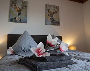 Gezellige slaapkamer in Ferienhaus Blick auf Dedenborn, Dedenborn - Simmerath, met kunstzinnige hertenprints en zachte verlichting.