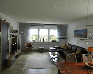 Gezellige woonkamer van vakantiehuis Eifelpanorama in Gnnersdorf, Rijnland-Palts, met comfortabel interieur en grote ramen.