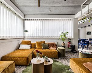 Comfortabele lounge in Gare 55 vakantiehuis Ertvelde, Oost-Vlaanderen, met veel natuurlijk licht.