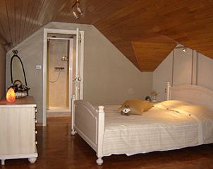 Gezellige slaapkamer met houten interieur in Gastenverblijf Wisteria, Herne.