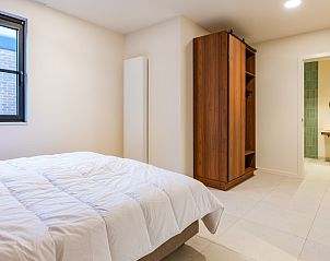 Ruime slaapkamer in 't Klooster vakantiehuis in Loonbeek, Vlaams-Brabant met een grote kast en directe toegang tot de badkamer.