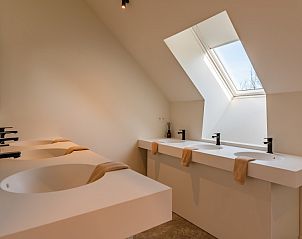 Stijlvolle badkamer in 't Klooster vakantiehuis in Loonbeek, Vlaams-Brabant met meerdere wastafels en veel natuurlijk licht.