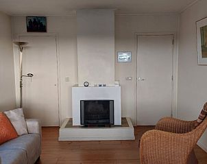 Gezellige woonkamer van bungalow Smaragd in Midsland aan Zee, Terschelling, met comfortabele zitplaatsen en een sfeervolle open haard.