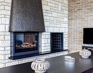 Moderne zithoek met open haard in 't Kareelbos vakantiehuis in Wezemaal, Vlaams-Brabant.