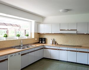 Volledig uitgeruste keuken in 't Kareelbos vakantiehuis in Wezemaal, Vlaams-Brabant, met uitzicht op de tuin.