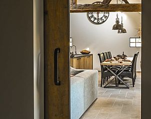 Gezellige eetkamer in Huisje in Begijnendijk, vakantiehuis in Vlaams-Brabant, Belgi, met rustieke houten details en comfortabele zithoek.