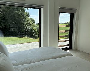 Slaapkamer met uitzicht op de tuin in The View vakantiehuis in Gooik, Vlaams-Brabant, perfect voor rust en ontspanning.