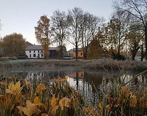 Herfstlandschap rondom Aan de Jordaan vakantiehuis in Willebringen, Vlaams-Brabant met vijver en kleurrijke bomen.
