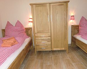 Gezellige slaapkamer in Ferienhof am Biberbach, Hrselberg-Hainich, met houten meubels en warme sfeer voor maximaal zes personen.