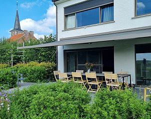 Terras van Villa Veldzicht in Glabbeek, Belgi met uitzicht op de tuin en kerk.