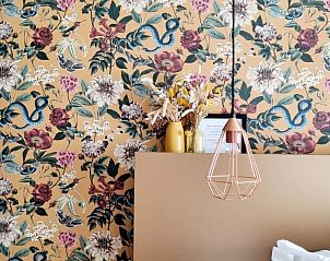 Decoratieve slaapkamer in Villa Veldzicht, Glabbeek met bloemenbehang en moderne lamp.