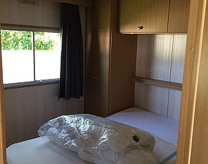 Komfortables Schlafzimmer im Mobilheim Kanoet, West Terschelling, mit gemtlichem Bett und Stauraum.