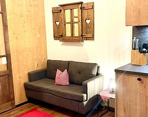 Gezellige woonkamer in Huisje in Samerberg, Beieren. Vakantiehuis met rustieke inrichting en comfortabele bank.