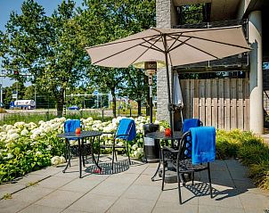 Buitenterras van Bastion Hotel Utrecht, Utrecht, met comfortabele zitjes en groene omgeving.