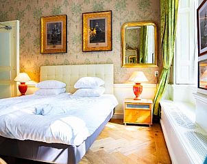 Lichte slaapkamer in Hotel Museumkwartier Utrecht, vakantie appartement met grote ramen en groene gordijnen.