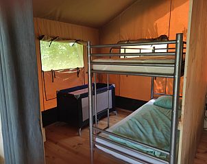 Slaapruimte in Safaritent Greenlodge, Chtel-Montagne, met stapelbedden en een rustieke sfeer in de Auvergne, Frankrijk.