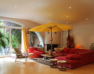 Le Loft vakantiehuis in Montluon, Auvergne biedt een stijlvolle woonkamer met comfortabele zithoek en uitzicht op de groene tuin.