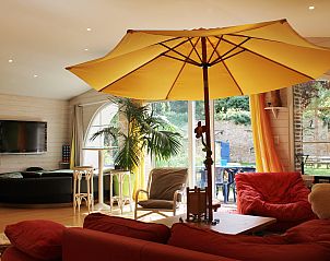 Gezellige woonkamer van Le Loft vakantiehuis in Montluon, Auvergne, met kleurrijke inrichting en grote ramen.