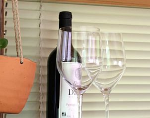 Geniet van een glas wijn in het vakantiehuisje in Ronnet, Auvergne, Frankrijk, met gezellige binnenruimte.