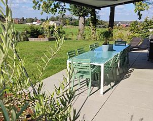 Terras met eettafel en uitzicht op de tuin bij Moderne villa met zwembad en kinderboerderij in Affligem, Belgi.