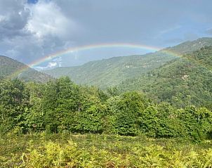Prachtige regenboog boven de groene heuvels bij Huisje in Cassaniouze, vakantiehuis in Auvergne, Frankrijk.