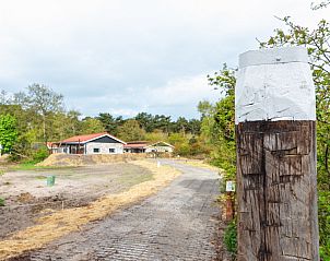 Toegangsweg naar Nesserduinen 42E, vakantiehuis in Nes, Ameland omgeven door groene natuur.