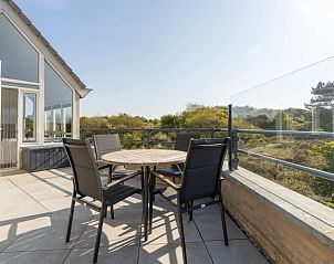 Ruim terras van Zand appartement in Nes, Ameland met uitzicht op de groene omgeving.