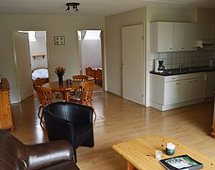 Gezellige woonkamer in Appartementen-Annema, Nes, Ameland met comfortabele zithoek en keuken voor een ontspannen verblijf op de Waddeneilanden.