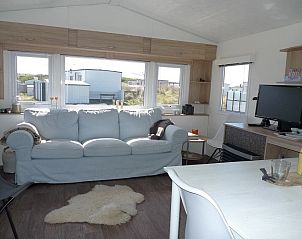 Lichte woonkamer in de Cirkel chalet, Nes, Ameland, met comfortabele bank en uitzicht op de omgeving.