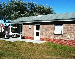 Zonnige buitenruimte van bungalow Klasina, Nes, Ameland met tuinmeubilair.