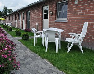 Outdoor terrace of Huisje in Brecht, a vacation home in Brecht, Antwerp, with seating area and flower garden.