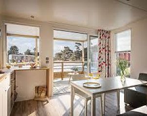 Heller Innenraum des Mobilheims Premium LIVING in Ploemeur, Bretagne, mit Blick auf die Natur.