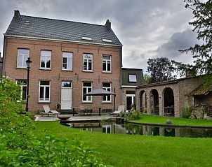 Achtertuin van Amand'eau vakantiehuis in Sint-Amands, Antwerpen met vijver en charmant terras.