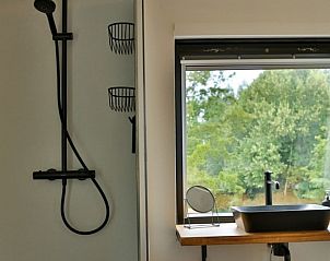 Stijlvolle douche en wastafel in Amand'eau vakantiehuis, Sint-Amands, Antwerpen met uitzicht op groene omgeving.